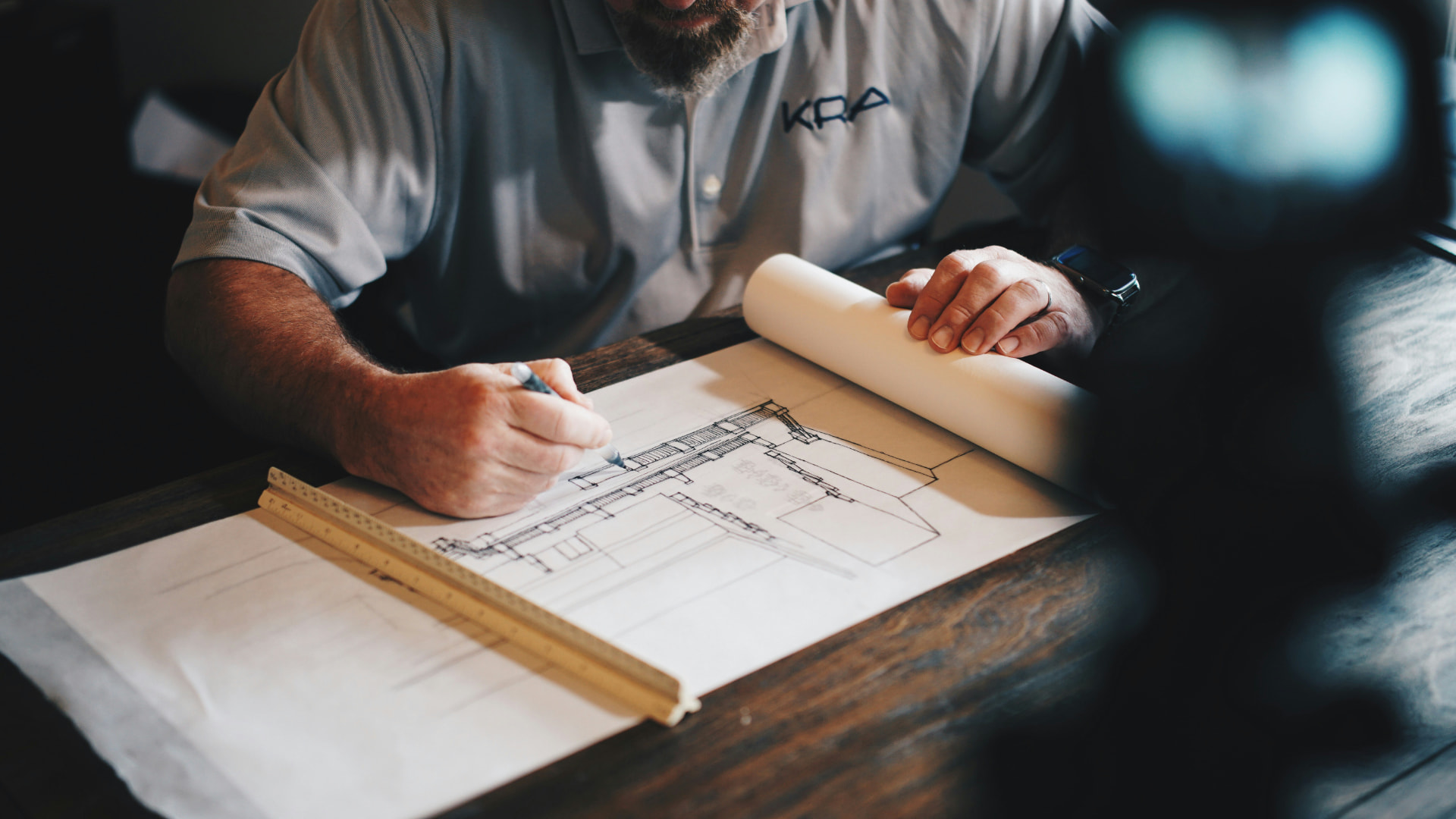 Bid manager sketching plans at a desk