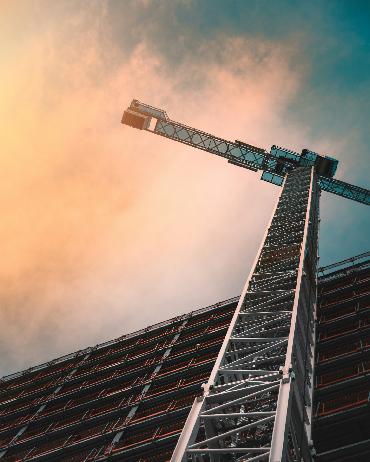 Construction crane reaching upward against a bright sky